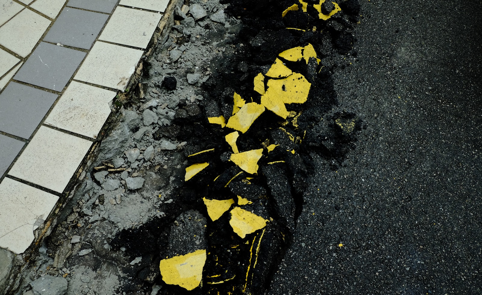 a yellow and black street sign on the side of a road